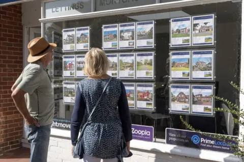 Getty Images Couple looking at estate agent window