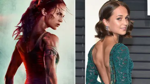 Warner Bros/Getty Images Alicia Vikander on the Tomb Raider poster and in the flesh