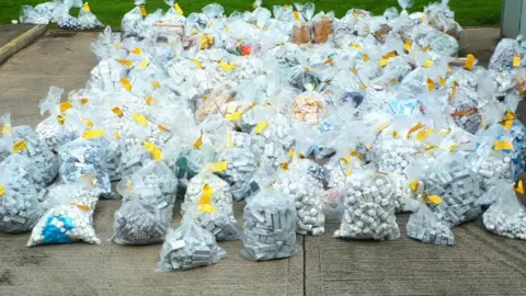 Crown Prosecution Service Dozens of big clear bags each stuffed full of little white bottles of drugs