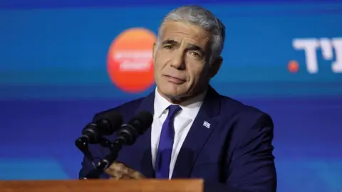 Reuters Caretaker Prime Minister Yair Lapid addresses supporters at the Yesh Atid party's election headquarters in Tel Aviv (2 November 2022)