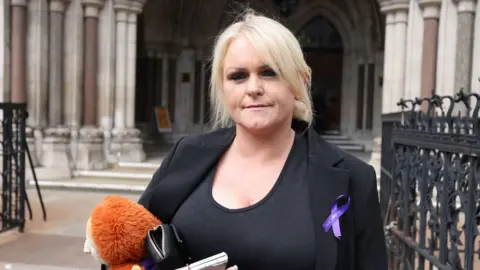 James Manning Hollie Dance, mother of Archie Battersbee, holding a soft toy and standing outside the High Court