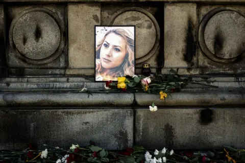 DIMITAR DILKOFF/AFP Flowers are placed near a portrait of slain Bulgarian television journalist Viktoria Marinova in the city of Ruse on 9 October 2018.