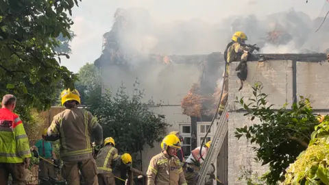 A fire in thatched roof of house in Urchfont