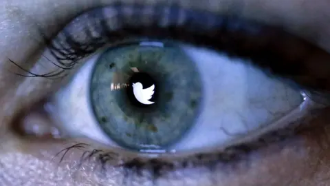 Reuters Twitter logo reflected in an eye