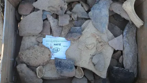 Dig Alderney A number of pottery shards in a box.