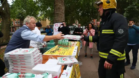 Reuters Pizzas and water being handed out