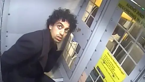 Met Police Screen grab taken from body worn camera footage dated 25/09/20 issued by the Metropolitan Police of Louis De Zoysa being put into a police van was shown to the jury
