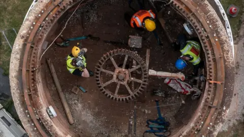 English Heritage Men inside the tower of Sibsey Trader Windmill