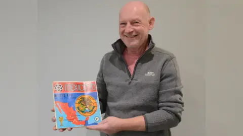 Gildings Auctioneers Andrew Knott with Panini sticker album