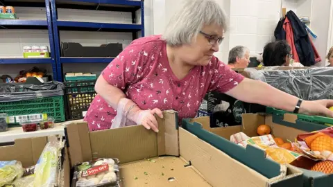 A woman putting food in a bag