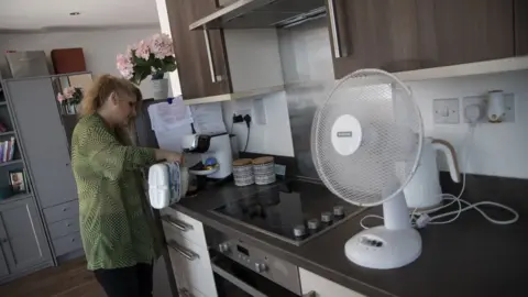 BBC News Jorda in her home in Harlsden, London. She is making a coffee in her kitchen