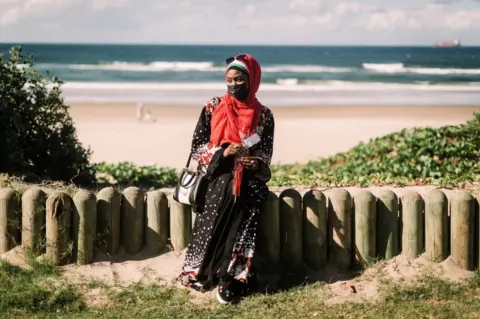AFP A woman sitting close to the beach clutches a rose.