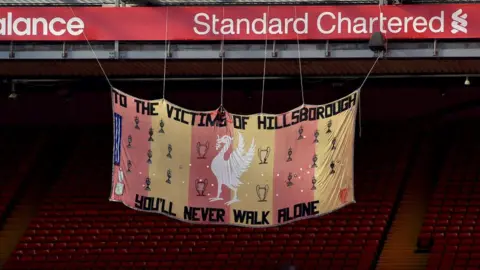 Liverpool FC Peter Carney's original Hillsborough memorial banner hanging at the Kop on 15 April 2020