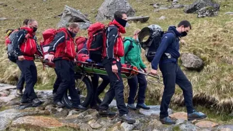 Llanberis Mountain Rescue Team The woman being transported down Snowdon by members of the Llanberis Mountain Rescue Team