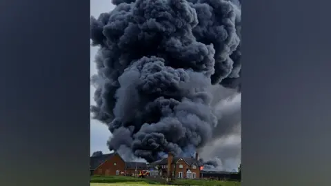 Market Drayton Fire Station A think plume of black smoke being emitted from a collection of buildings