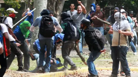 AFP Members of a 'colectivo' pro government group beat an opposition student who was taking part in a protest in Caracas on 3 April 2014