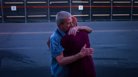 Getty Images Marcel Larrivee (L) comforts Patricia Landry after the pair first witnessed the aftermath of the destruction