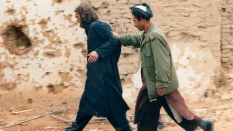 Reuters John Walker Lindh, left, photographed as he is captured by Northern Alliance Afghan forces in 2001