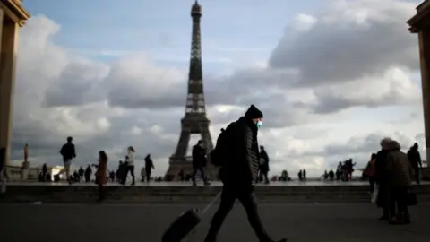 Reuters A man wearing a protective face mask walks at Trocadero square near the Eiffel Tower in Paris