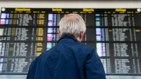 E:PA A man stands in front of the departure board at Brussels Airport in Zaventem, Belgium (23 August 2017)