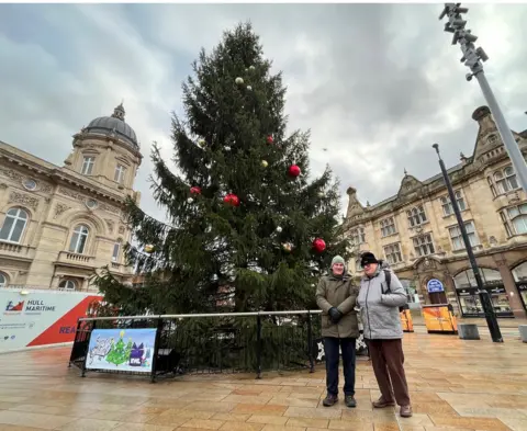BBC Graham pictured with his coach Geoff in Hull city centre. They are standing in front of a Christmas tree.