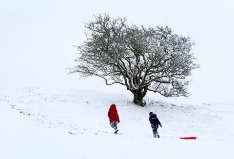 PA Media People go sledging on Farthing Common in Kent, on 8 February