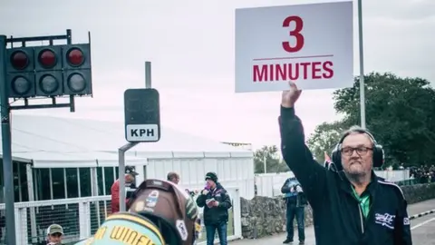 STEVE BABB An official signalling three minutes to the start of a qualifying session