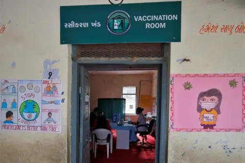 Reuters Healthcare workers sit inside a classroom of a school, which has been converted into a temporary vaccination centre, during a nationwide trial run of COVID-19 vaccine delivery systems, on the outskirts of Ahmedabad, India.