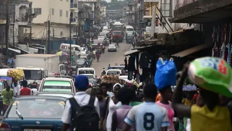 AFP/Getty People walking in a street in Freetown, Sierra Leone