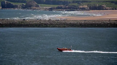 RNLI Cullercoats RNLI lifeboat returns to sea after transferring the girl they rescued from drowning to the care of paramedics