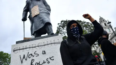 Reuters A protester stands in front of the Churchill statue