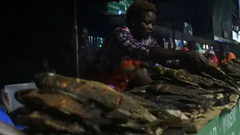 Getty Images A woman at the Nairobi West fish mongers sell freshly caught and cooked fish on September 18, 2019 in Nairobi.
