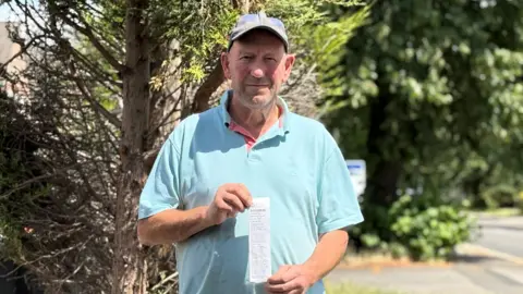 BBC Frank Brown holding the fixed penalty notice