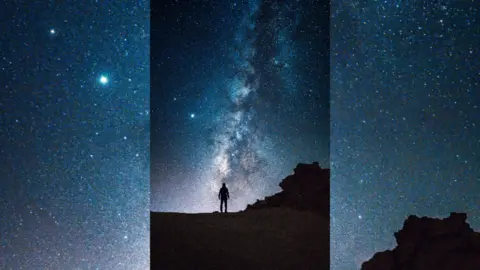 Silhouette of a person on. hilltop observing the Milky Way in the sky.