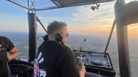 Eats Everything Eats Everything DJing in the air with the sun starting to set ahead of him