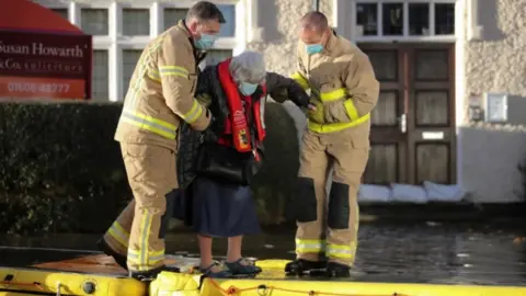 Reuters Firefighters helping people to safety