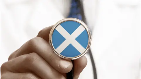 Getty Images Doctor holding stethoscope with saltire