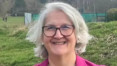 Edna Murphy Edna Murphy standing against a fence with a green area behind