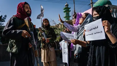 Getty Images Taliban fighters approach female protestors in Kabul