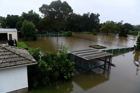 Reuters Floodwater completely submerges the backyards of properties on Ladbury Ave, in Penrith, New South Wales, Australia, 21 March 2021.