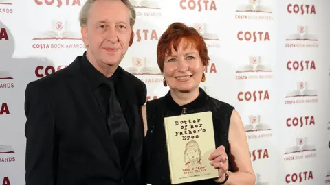 Getty Images A man and a woman hold a book