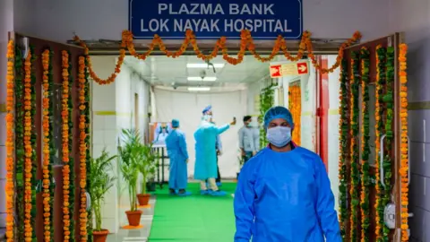 Getty Images A technician wearing a personal protective Equipment suit (PPE) is seen coming from the Plasma Bank. Delhi's second plasma bank started today. Delhi has the highest Covid-19 recovery rate within the whole of India