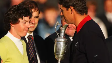 Padraig Harrington shakes hands with Sergio Garcia after beating him to the 2007 Open Championship title, while holding the Claret Jug and Rory McIlroy looks on