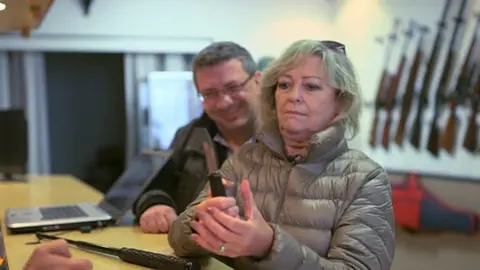 Ann Barnes is shown weapons for sale in France