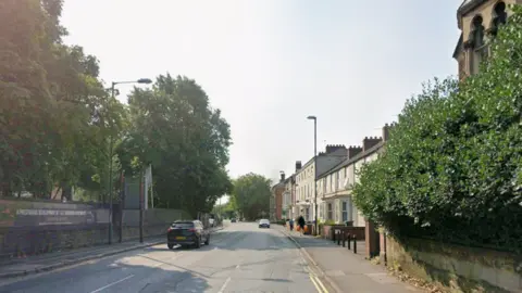 Osmaston Road, with properties of the right and a stone wall on the left