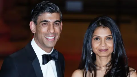 PA Media Rishi Sunak in black tie with his wife Akshata Murthy