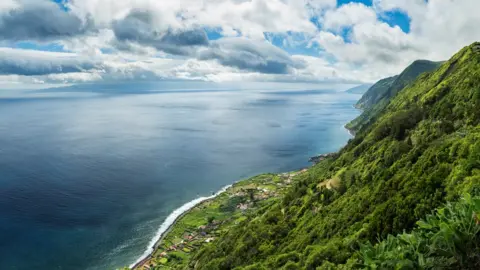 Getty Images The green coastline of Sao Jorge Island on a calm day.