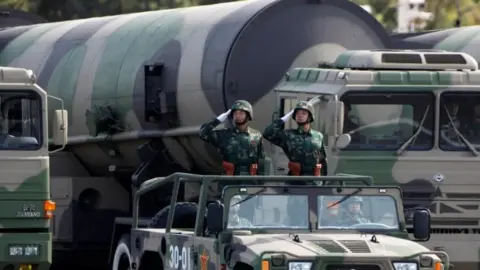 Reuters Chinese troops salute in front of nuclear-capable missiles during a massive parade to mark the 60th anniversary of the founding of the People"s Republic of China in Beijing - 2009 photo