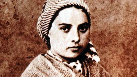 Getty Images An portrait in greyscale of St Bernadette - she is a young girl at the time and is wearing a headscarf and shawl