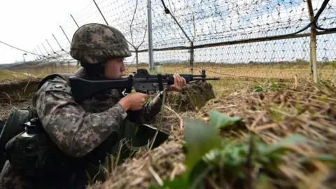 Getty AFP A South Korean soldier stands guard in front of a military fence at a General Outpost (GOP) of the Demilitarized Zone dividing the two Koreas in Cheorwon on October 13, 2015.